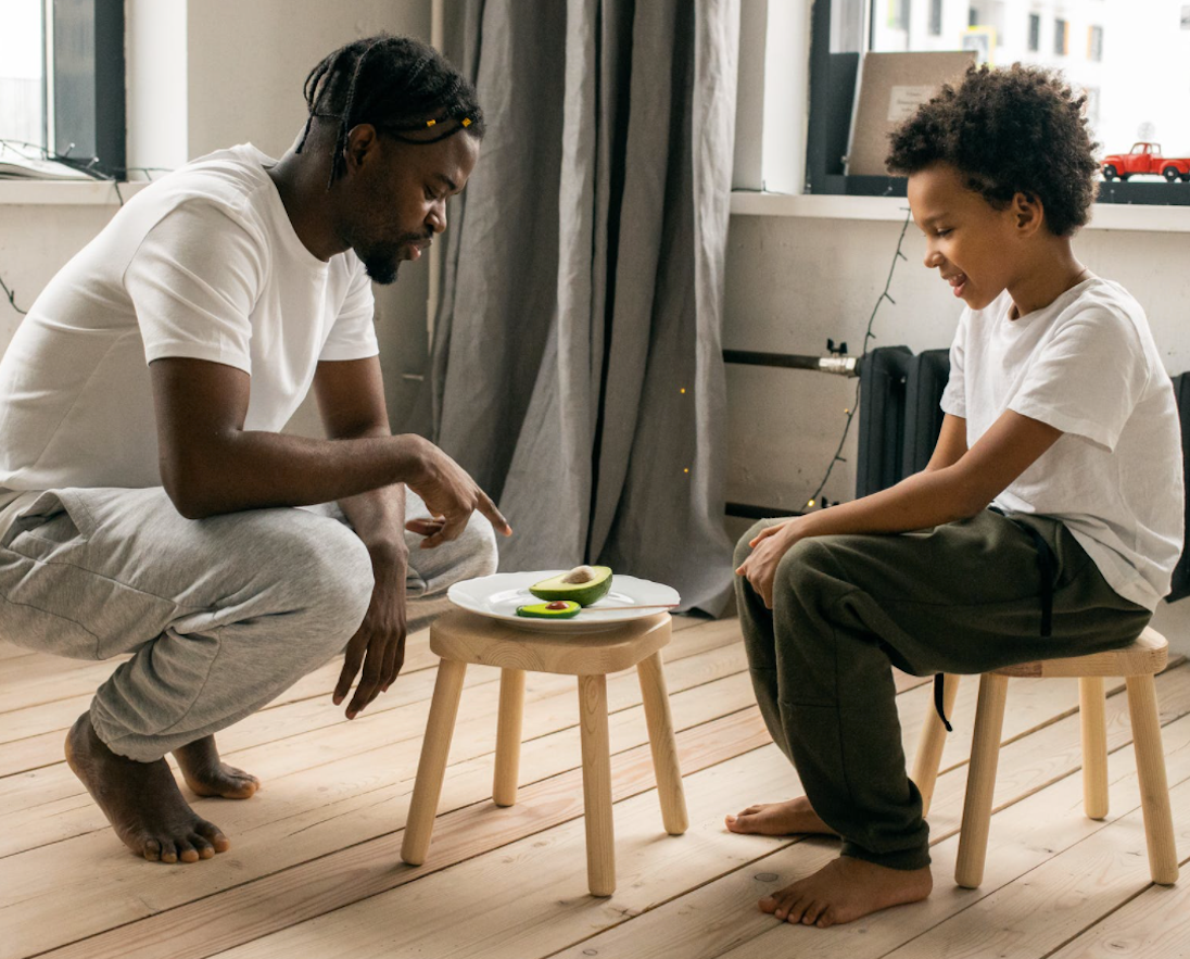 father and son eating avocado together